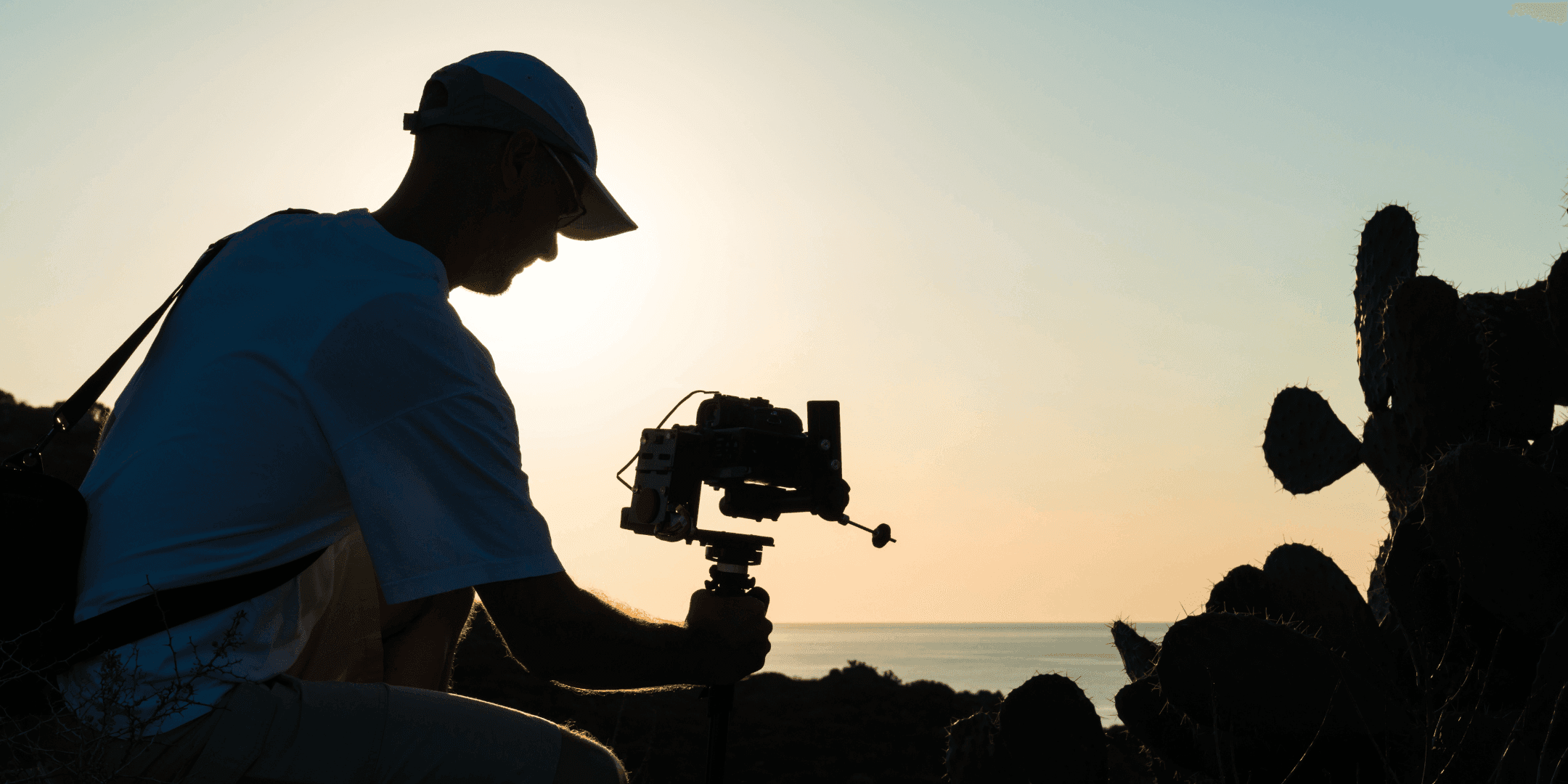 A man with a camera looking out over the ocean